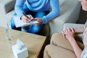 A person sitting on the couch writing something