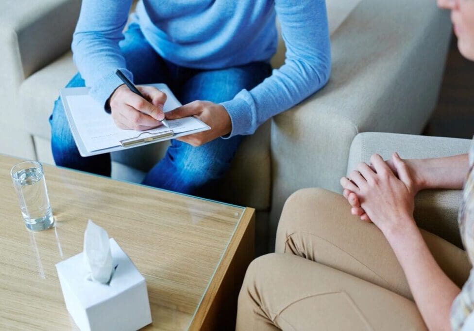 A person sitting on the couch writing something